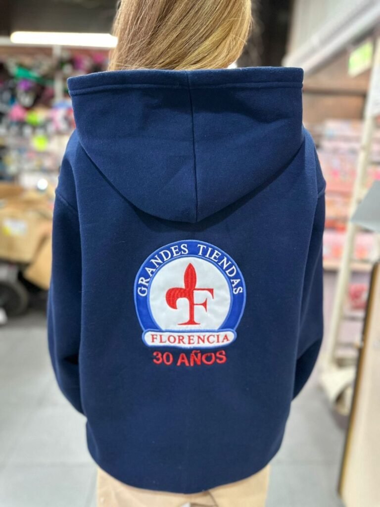 Buzo azul con el escudo bordado de Grandes Tiendas Florencia en la espalda