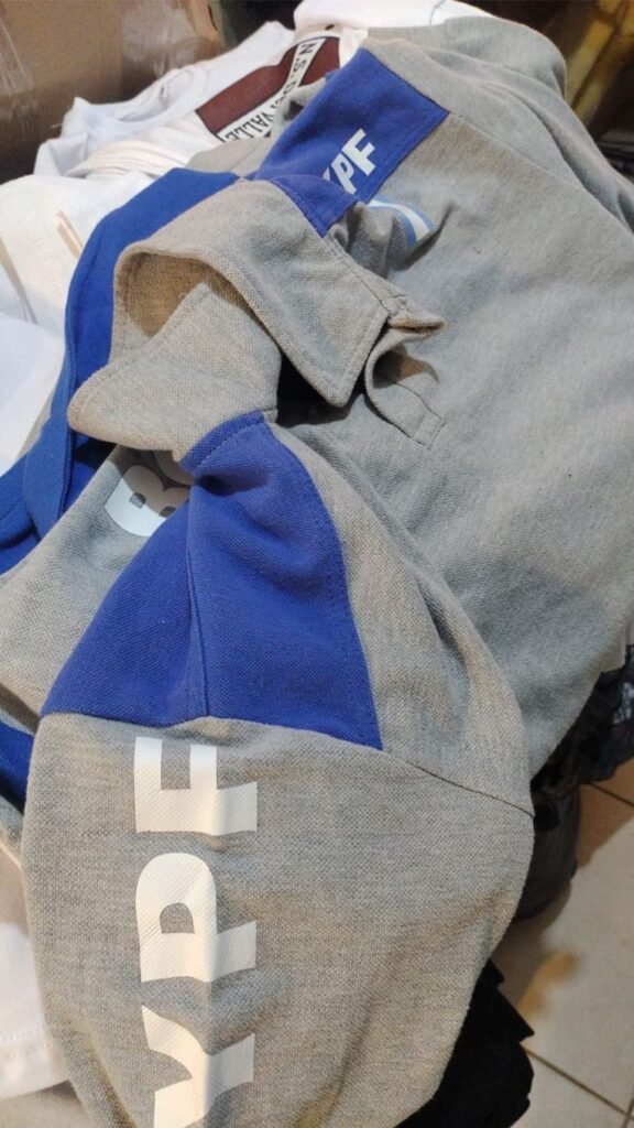 Buzos grises y azules con el logo de YPF en la manga