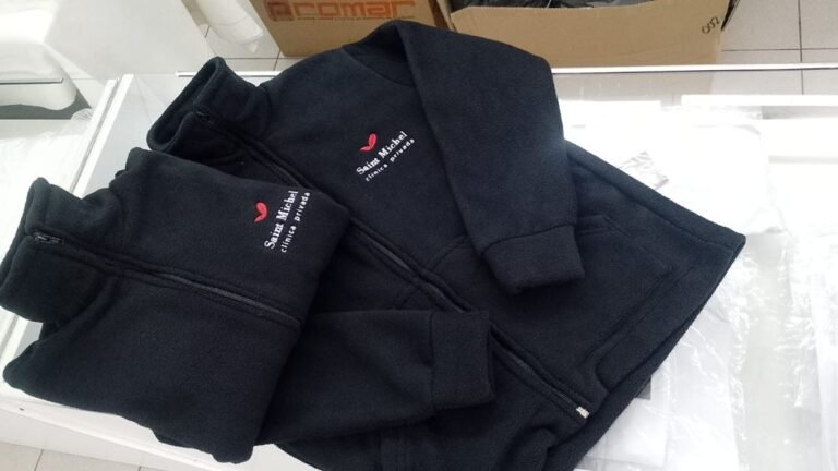 Prendas azul oscuro dobladas con logo bordado